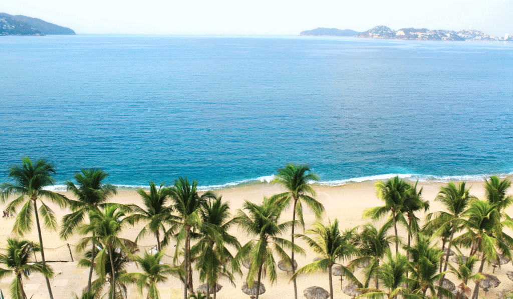 The sun-kissed shores of Acapulco Beach, Mexico, where golden sands meet the gentle waves of the Pacific Ocean.
