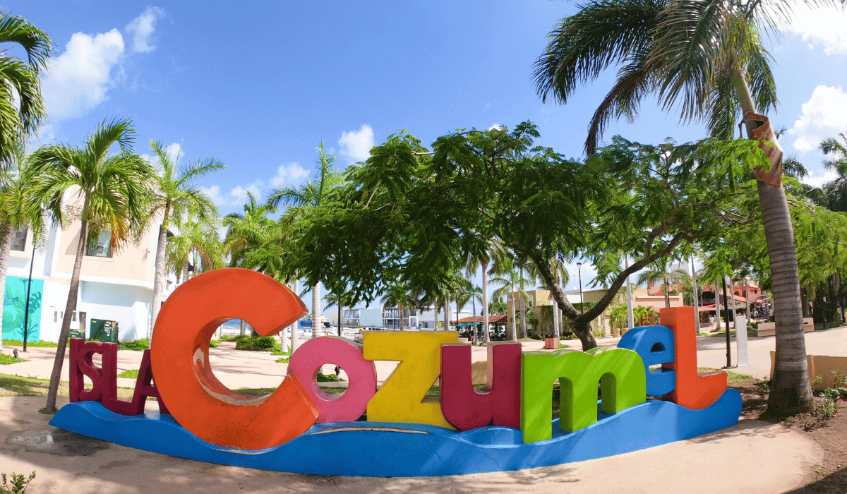 An attractive 'Isla Cozumel' sign in Mexico. The sign features vibrant colors and typography, welcoming visitors to the beautiful island of Cozumel. It is set against a backdrop of lush greenery, representing the island's tropical charm and warm hospitality.
