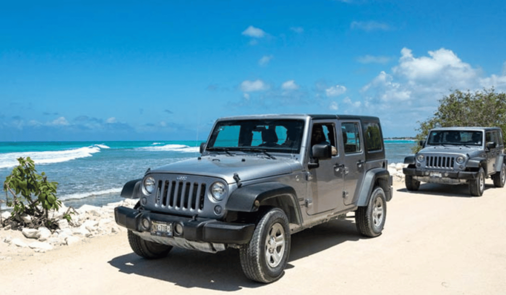 A rugged jeep adventure in Cozumel, Mexico. The image features a sturdy jeep driving along a scenic off-road trail on Cozumel Island. The jeep is surrounded by lush vegetation, and the trail winds through the island's natural beauty. Jeep excursions in Cozumel offer a thrilling way to explore the island's diverse landscapes and picturesque terrain.